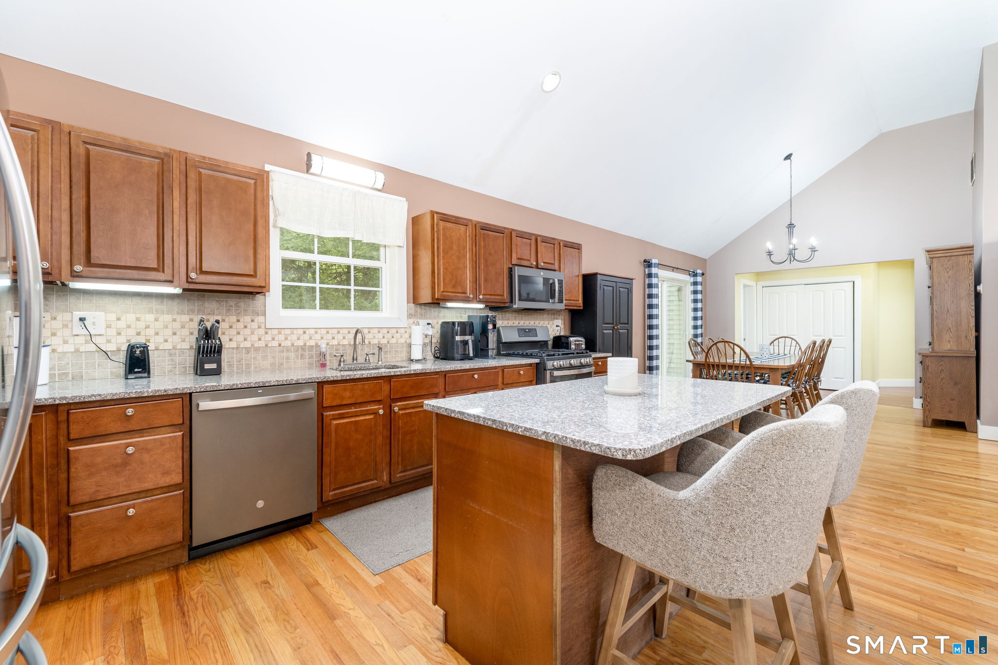 29 Old Simsbury Road Granby, CT 06035 - Photo 7 of 34 The kitchen with vaulted ceilings, hardwood floors, granite counters, an island with seating and stainless steel appliances.