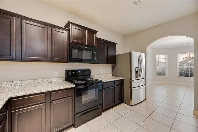 a kitchen with stainless steel appliances granite countertop a refrigerator sink and stove