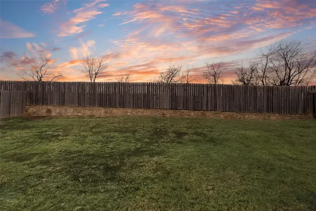 a view of yard with swimming pool and wooden fence