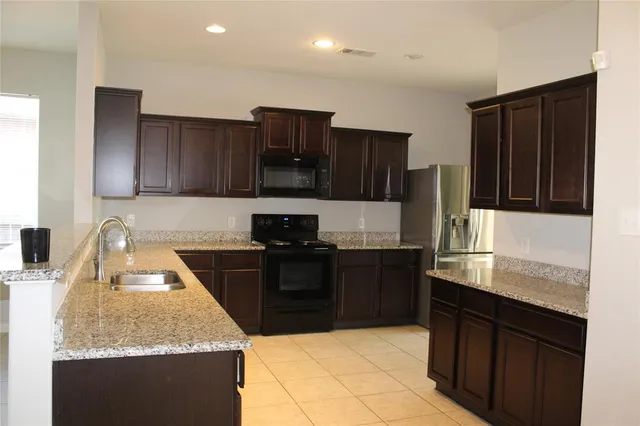 a kitchen with granite countertop stainless steel appliances and wooden cabinets