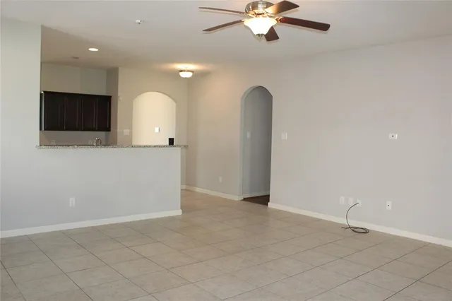 an empty room with fan and entrance