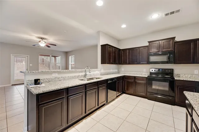 a kitchen with stainless steel appliances granite countertop a sink and stove top oven with wooden floor