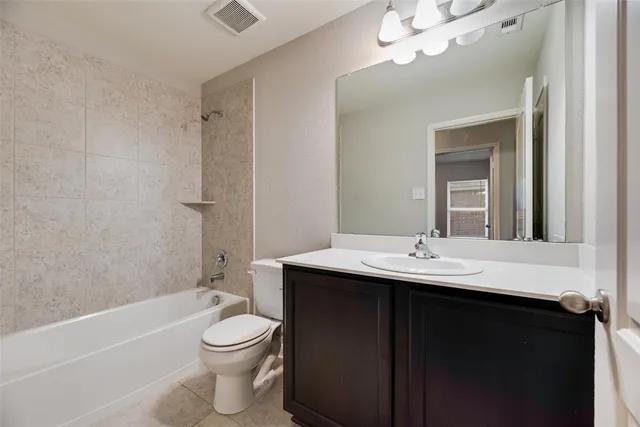 a bathroom with a toilet a sink a mirror a bathtub and vanity