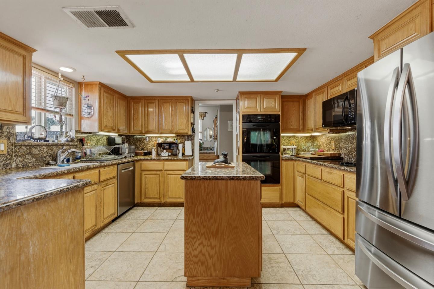 38780 Dinosaur Point Road Hollister, CA 95023 - Photo 6 of 34 a kitchen with stainless steel appliances granite countertop a stove top oven a refrigerator a sink and dishwasher
