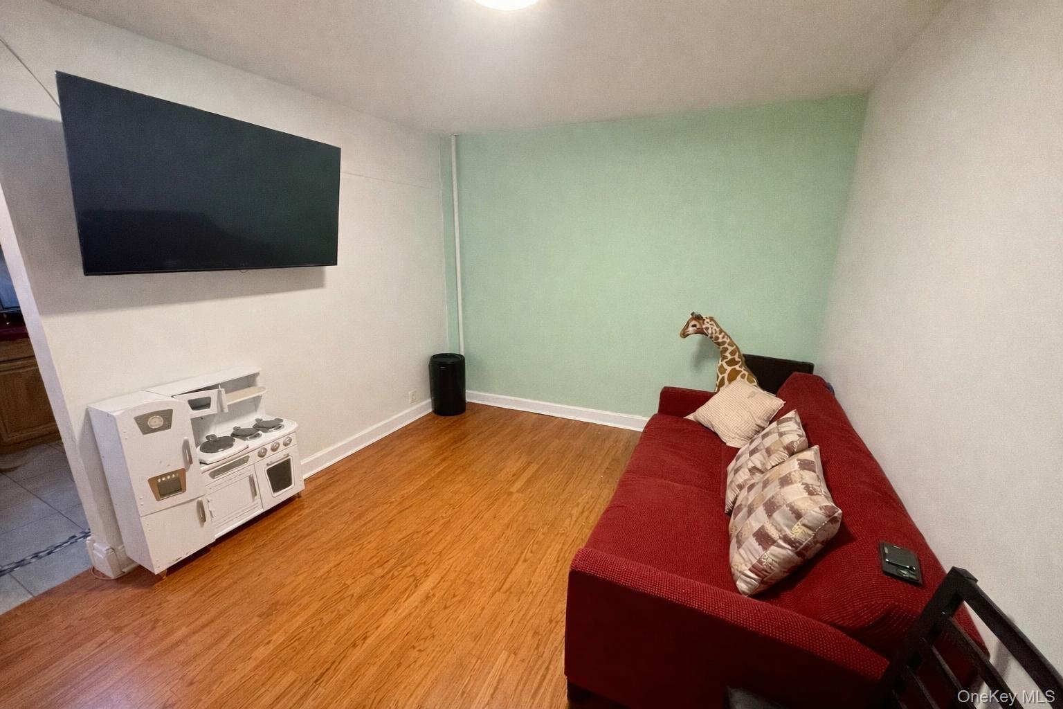 86-75 80th Street Queens, NY 11421 - Photo 18 of 29 a living room with furniture and a flat screen tv