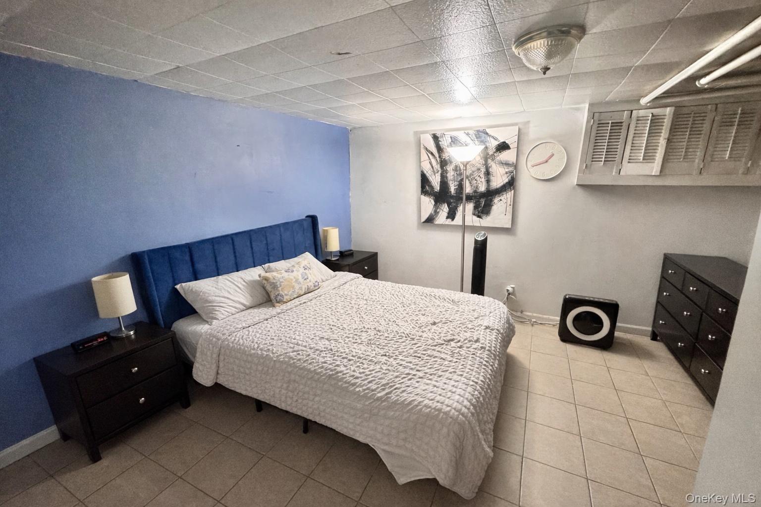 86-75 80th Street Queens, NY 11421 - Photo 20 of 29 a bedroom with a bed and wall painting