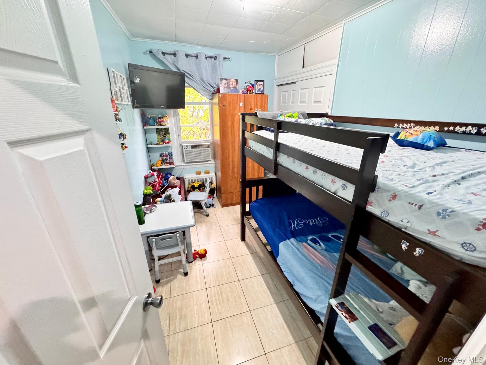 86-75 80th Street Queens, NY 11421 - Photo 9 of 29 a room with furniture and a flat screen tv