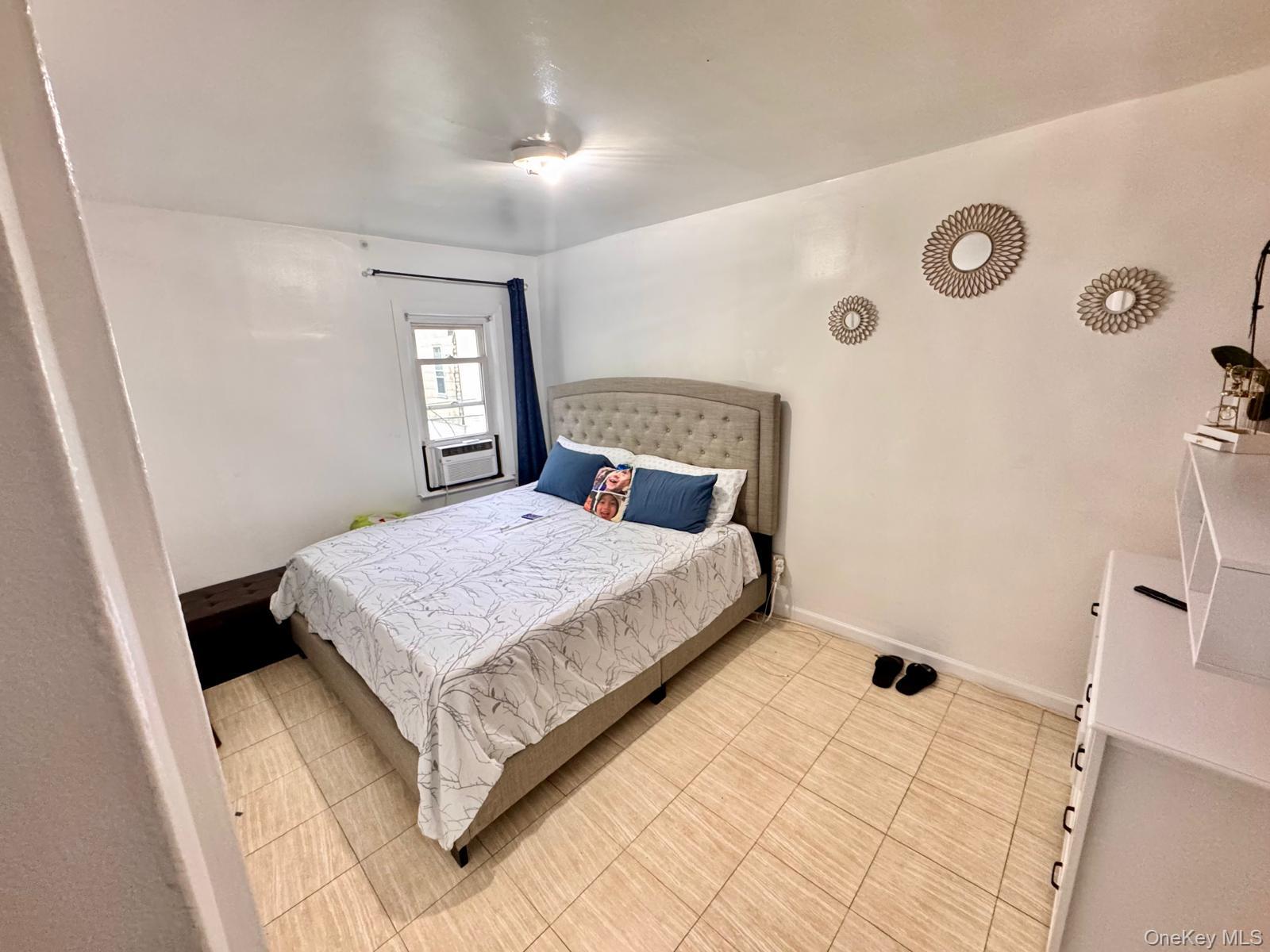 86-75 80th Street Queens, NY 11421 - Photo 10 of 29 a bedroom with a bed and a window