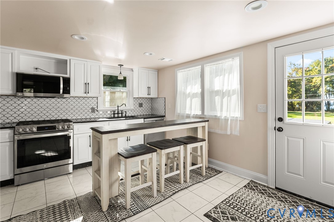 467 Blundon Road Reedville, VA 22539 - Photo 11 of 35 a kitchen with stainless steel appliances granite countertop a stove a sink and a microwave