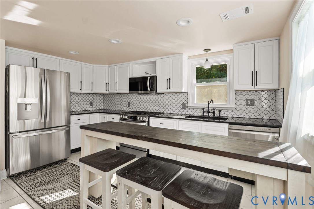 467 Blundon Road Reedville, VA 22539 - Photo 12 of 35 a kitchen with kitchen island granite countertop a sink stove and refrigerator