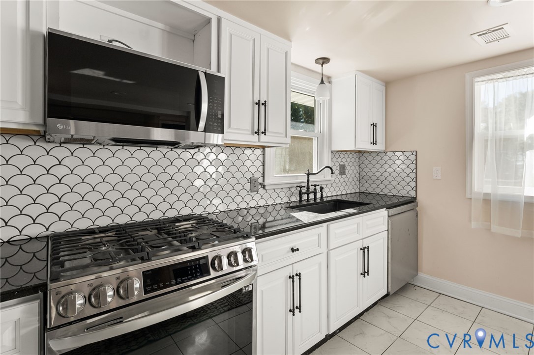 467 Blundon Road Reedville, VA 22539 - Photo 14 of 35 a kitchen with stainless steel appliances a stove a microwave a sink and cabinets