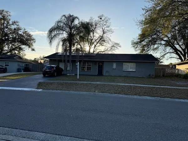 a front view of a house with a garden and trees