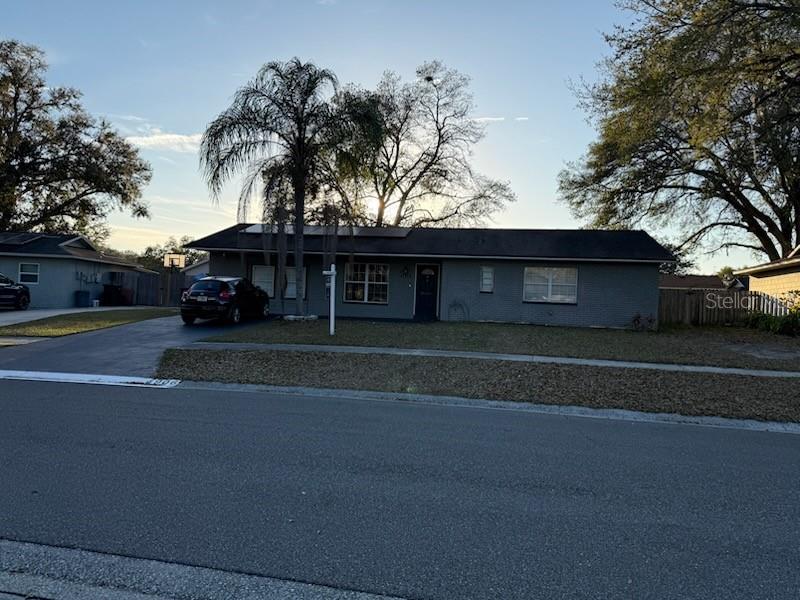 a front view of a house with a garden and trees