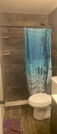 a bathroom with a toilet and a shower