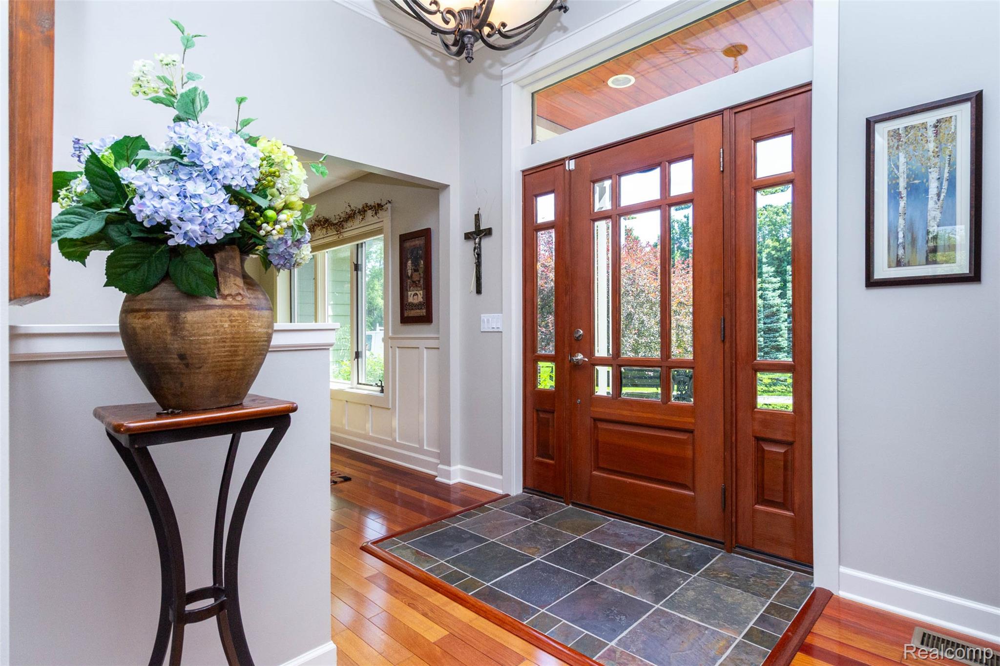 9887 Hadley Road Clarkston, MI 48348 - Photo 5 of 56 Entryway featuring a rich wood-finish front door with multiple glass panes and sidelights, a slate tile floor insert, and hardwood flooring