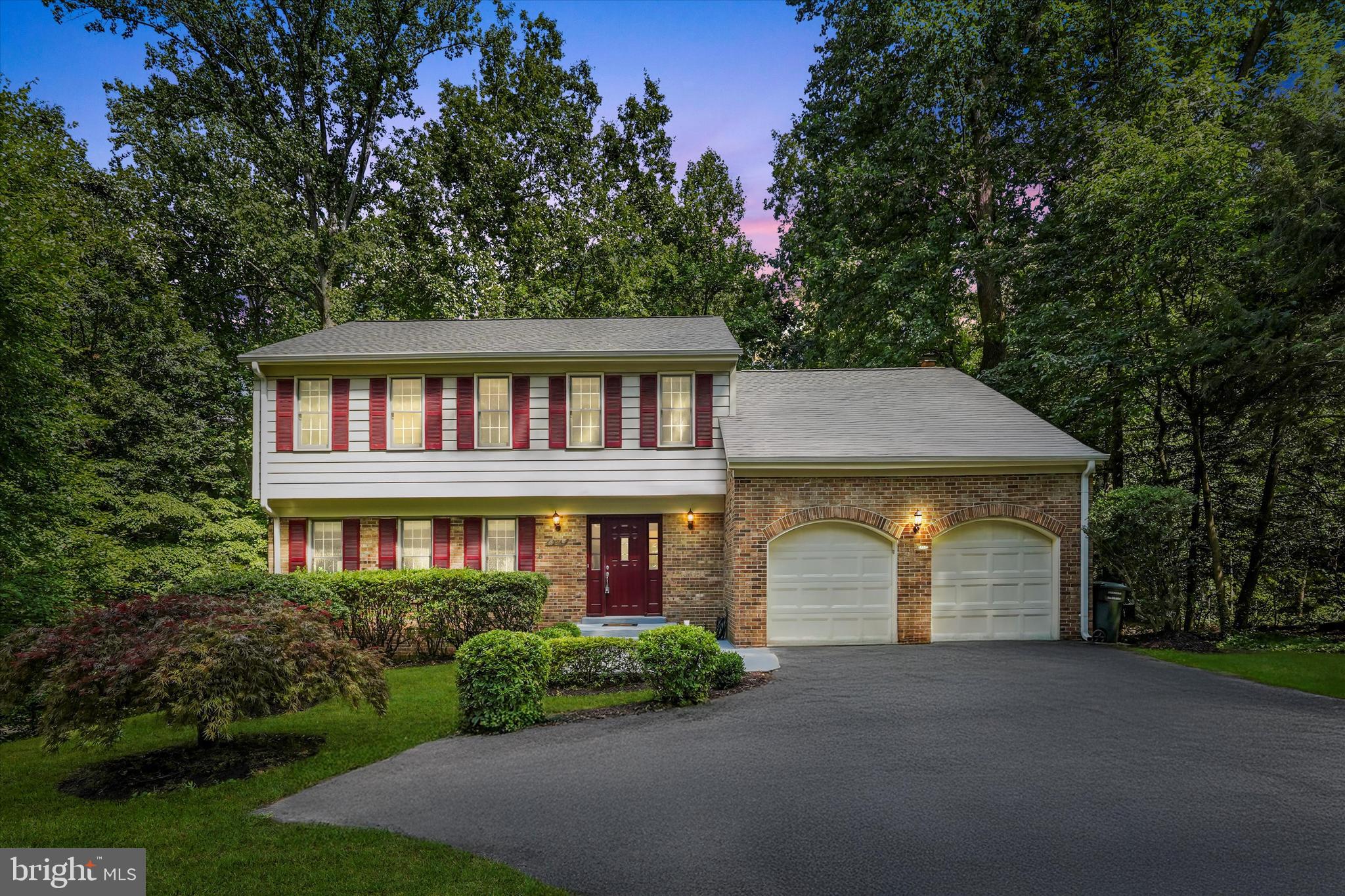a front view of a house with a garden and garage