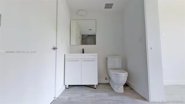 a bathroom with a toilet sink and a mirror