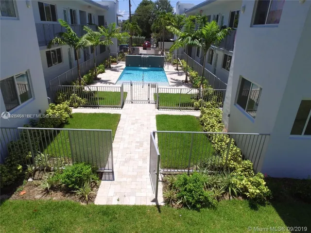 a view of a house with a backyard and sitting area