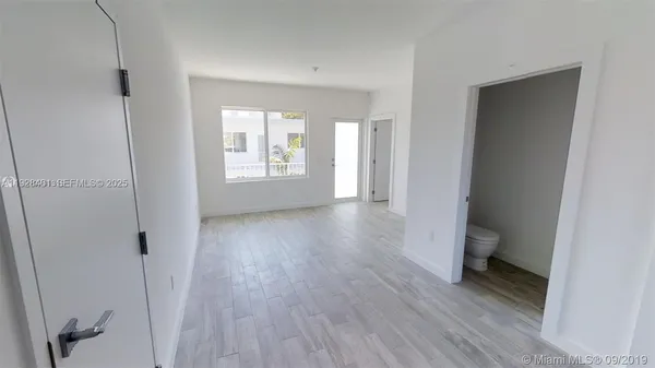 a view of a room with wooden floor and a window