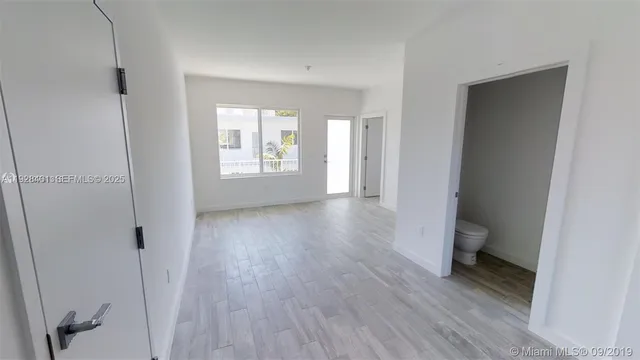 a view of a room with wooden floor and a window