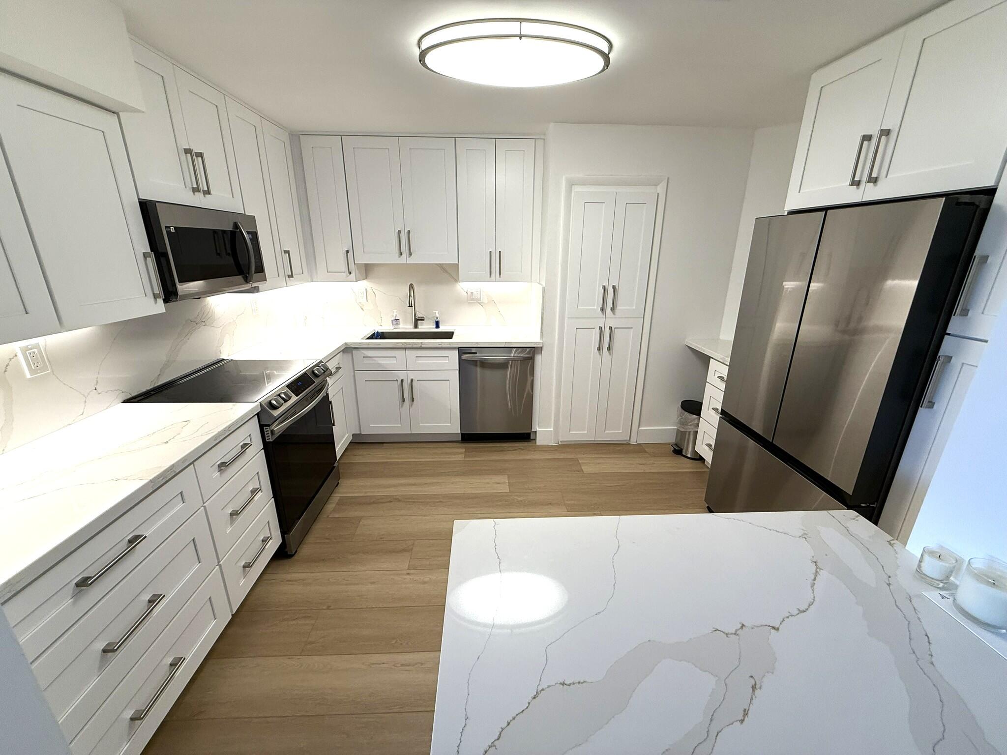 a kitchen with a sink a refrigerator a microwave and cabinets