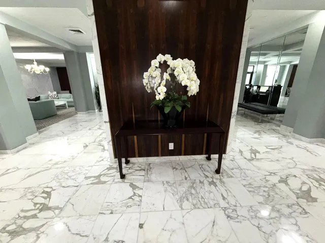 a view of a hallway with furniture and a window