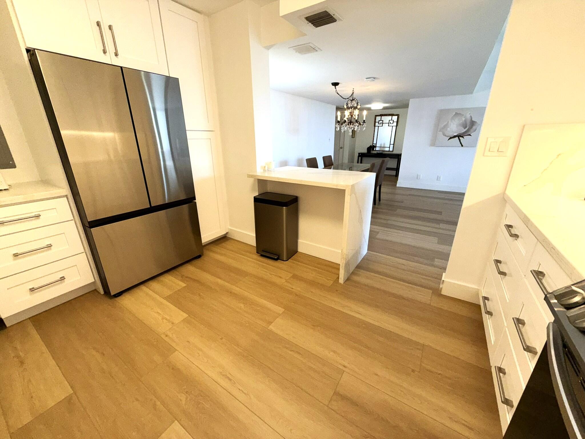2860 South Ocean Boulevard, Unit 415 Palm Beach, FL 33480 - Photo 3 of 24 a kitchen with stainless steel appliances a refrigerator a sink a stove top oven and cabinets