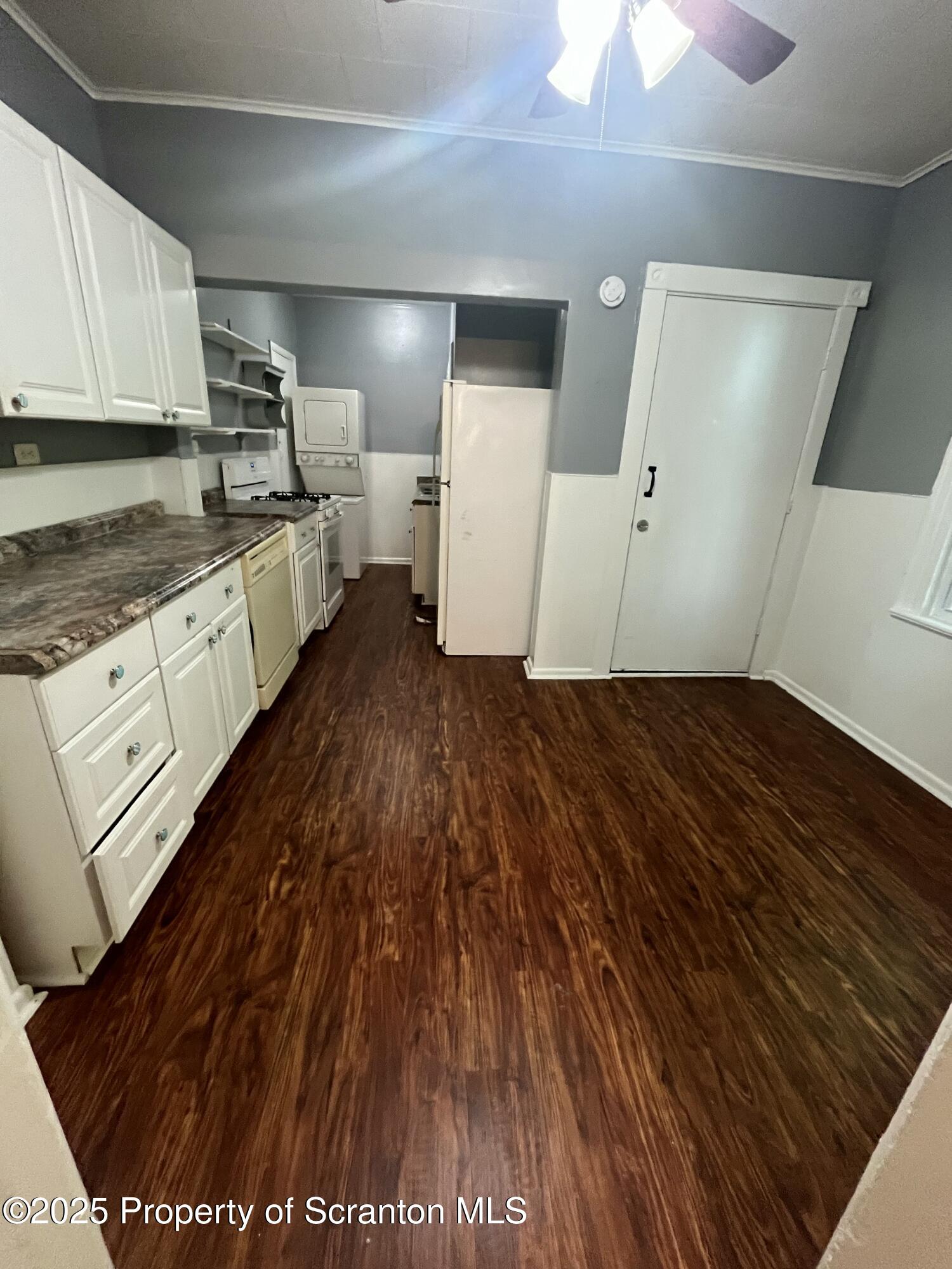 a kitchen with granite countertop a refrigerator and a stove top oven