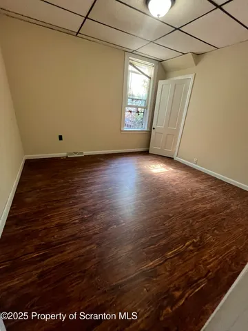 a view of room with window and wooden floor