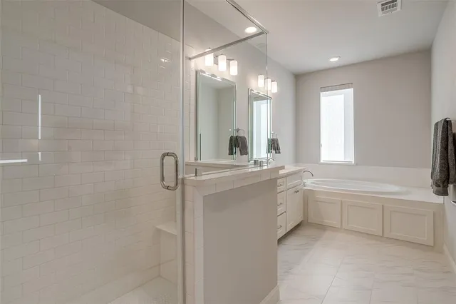 a bathroom with a double vanity sink a toilet and a bathtub