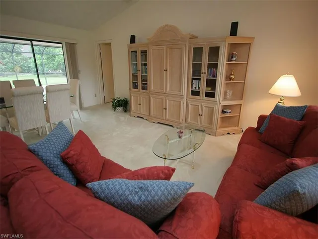 a living room with furniture cabinets and a window