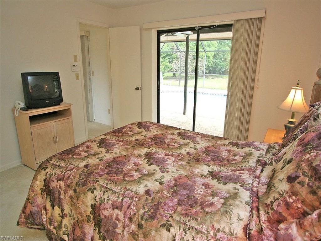 1961 Imperial Golf Course Boulevard Naples, FL 34110 - Photo 8 of 13 a bedroom with a bed and flat screen tv