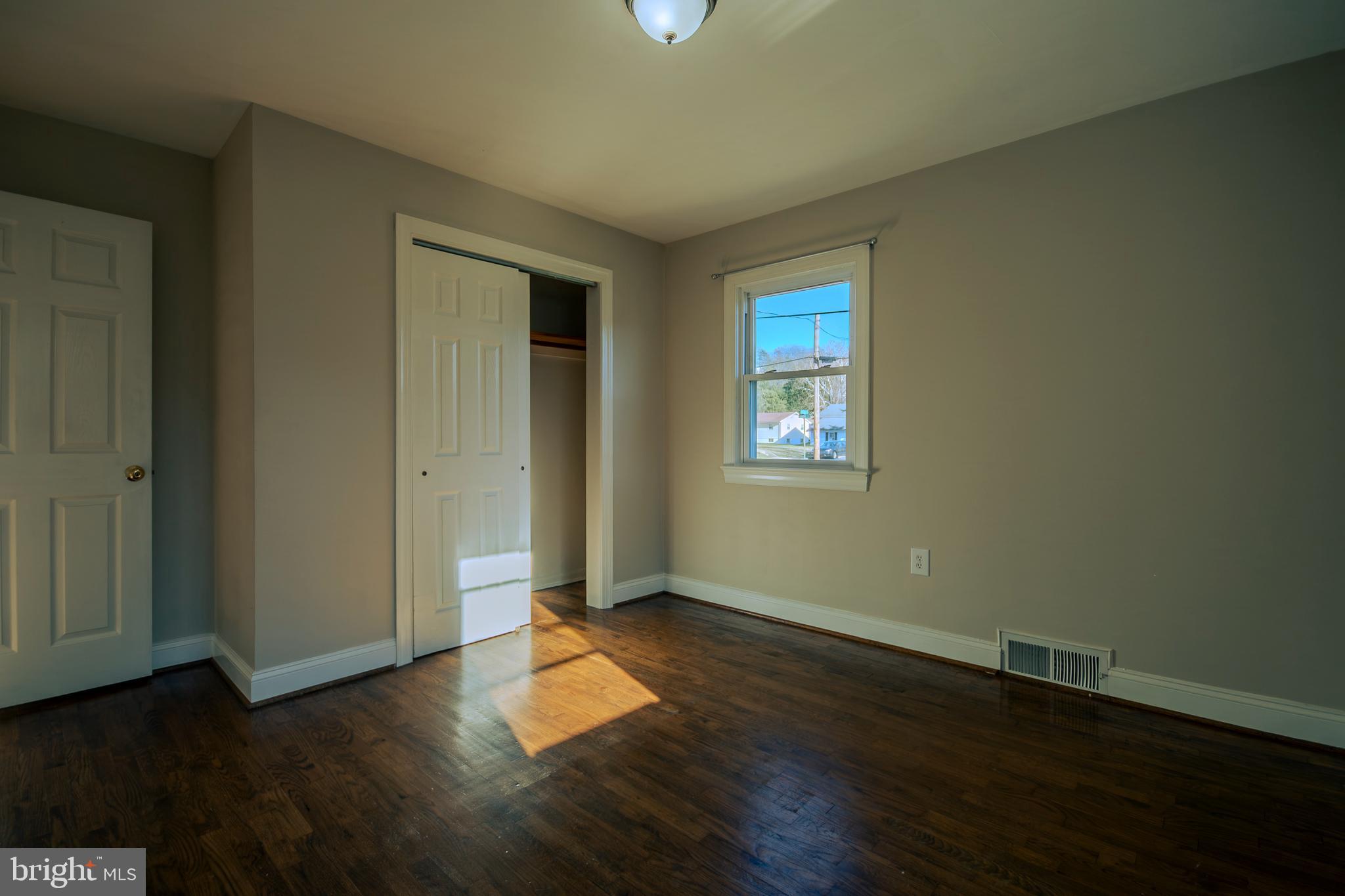 219 Virginia Street Strasburg, VA 22657 - Photo 10 of 29 an empty room with wooden floor and windows