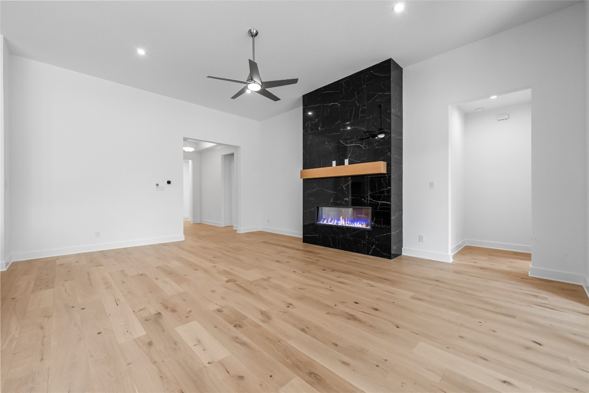 1304 Novara Trail Leander, TX 78641 - Photo 3 of 25 a view of an empty room with a fireplace and a ceiling fan