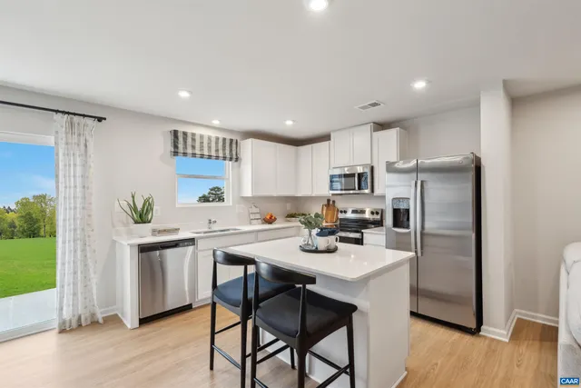 a kitchen with a sink a refrigerator a stove a dining table and chairs