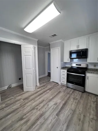 a kitchen with wooden floors and black appliances