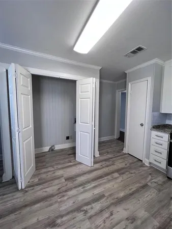 an empty room with wooden floor and closet