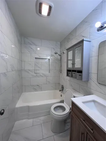 a bathroom with a bathtub a sink a toilet and a mirror