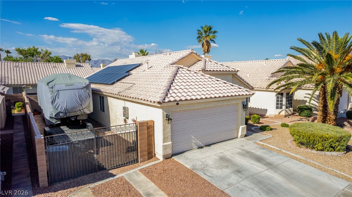 5112 West Camino Del Rancho Las Vegas, NV 89130 - Photo 35 of 44 This residence features a tiled roof and a two-car garage with an inviting, well-maintained front yard.