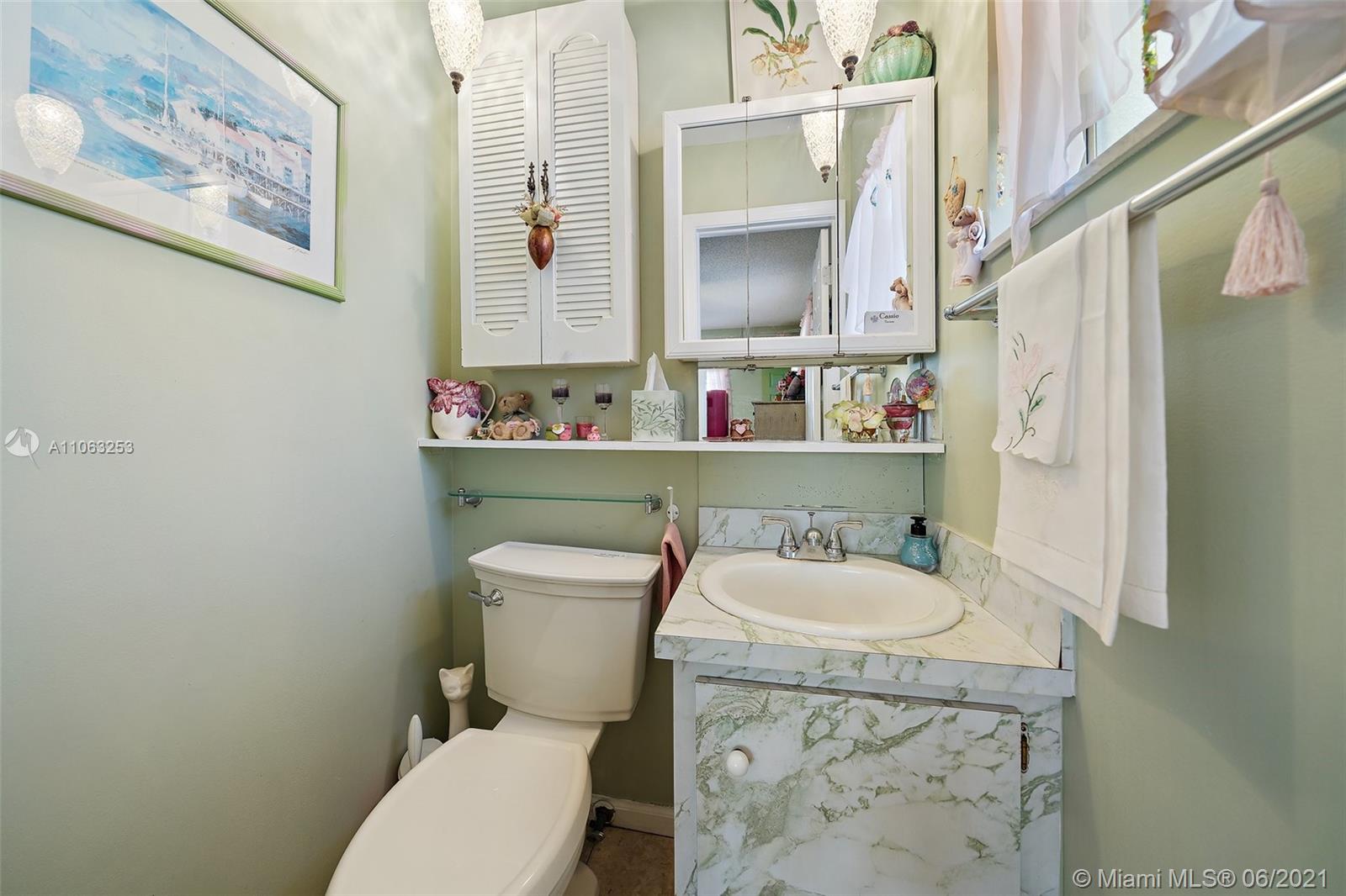 19 Shay Place Tequesta, FL 33469 - Photo 27 of 54 a white toilet sitting next to a bathroom sink