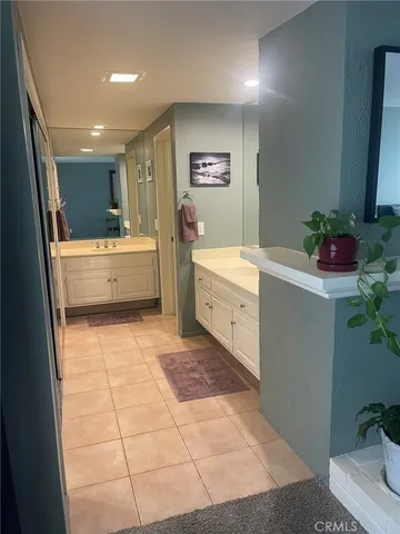 a room with painting on the wall and a potted plant