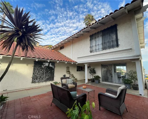 a view of a patio with couches table and chairs and potted plants