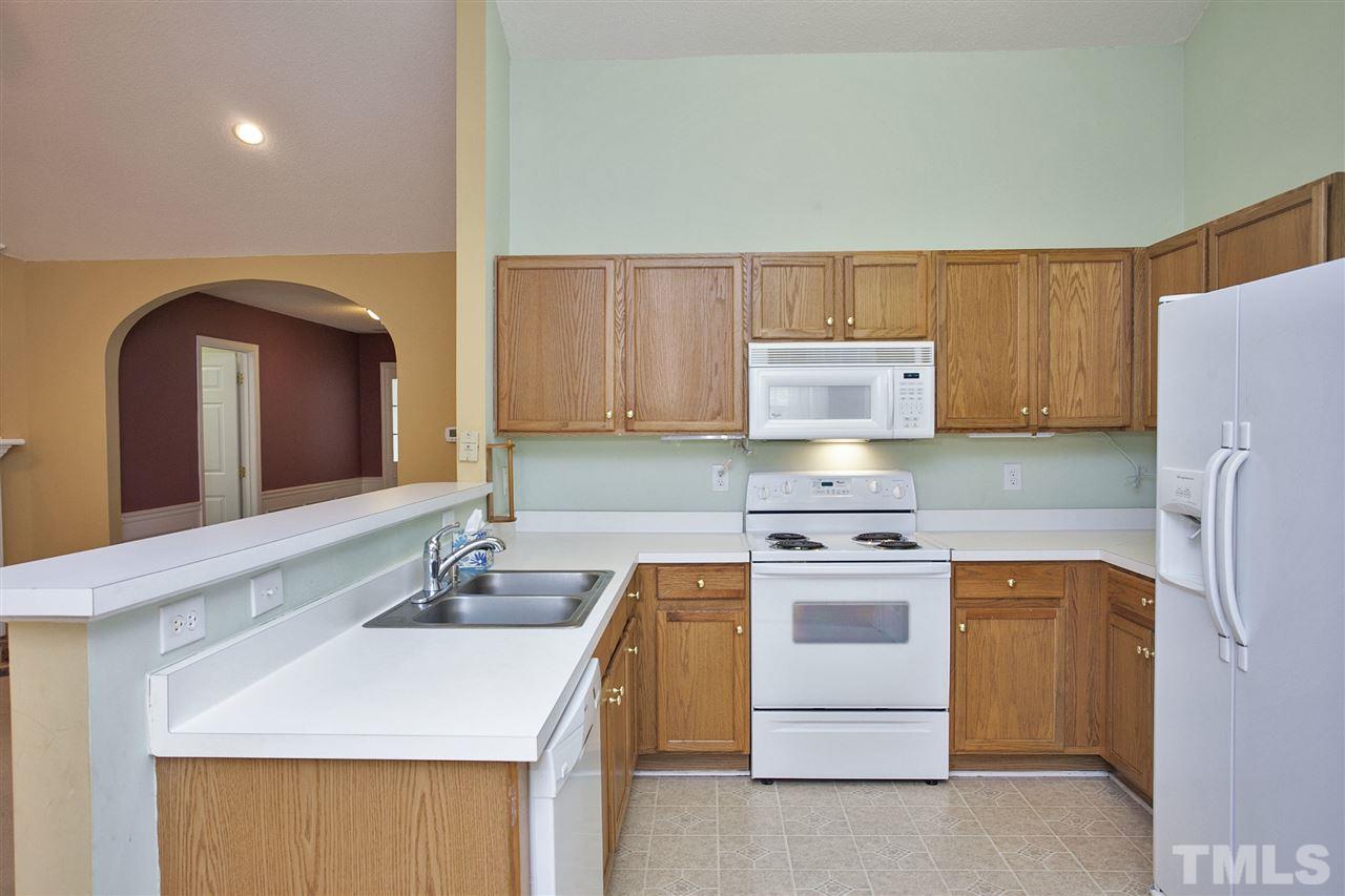 4513 Drewbridge Way Raleigh, NC 27604 - Photo 14 of 25 a kitchen with a stove sink and cabinets