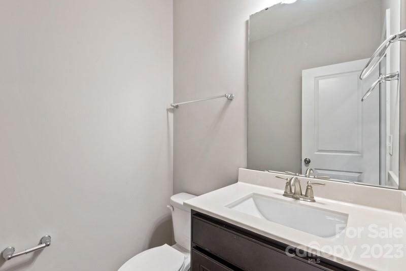 208 Waterlynn Ridge Road, Unit D Mooresville, NC 28117 - Photo 13 of 23 a bathroom with a granite countertop sink a toilet and a mirror