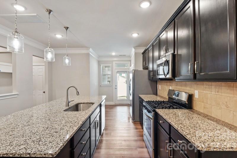 208 Waterlynn Ridge Road, Unit D Mooresville, NC 28117 - Photo 9 of 23 a kitchen with stainless steel appliances granite countertop a sink stove and refrigerator