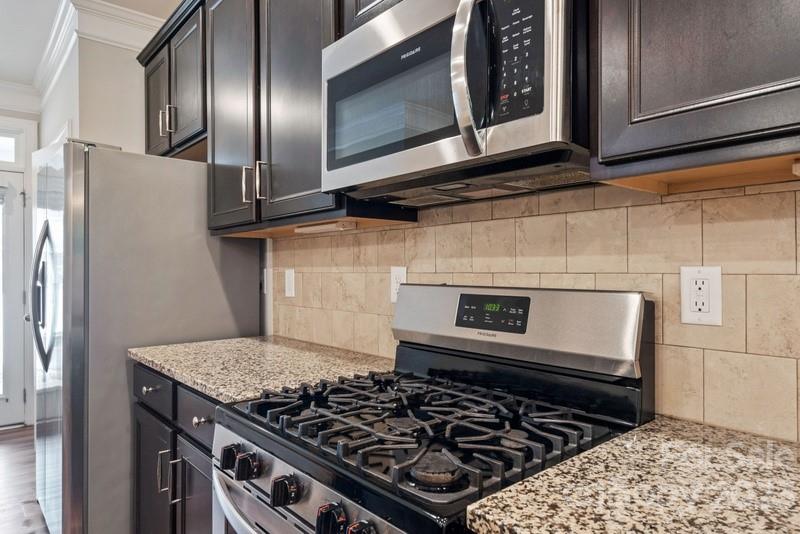 208 Waterlynn Ridge Road, Unit D Mooresville, NC 28117 - Photo 10 of 23 a kitchen with wooden cabinets and a stove top oven