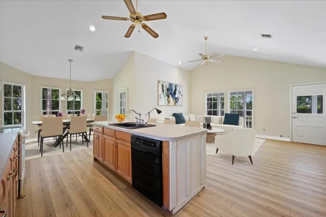 a living room with stainless steel appliances granite countertop furniture wooden floor and a fireplace
