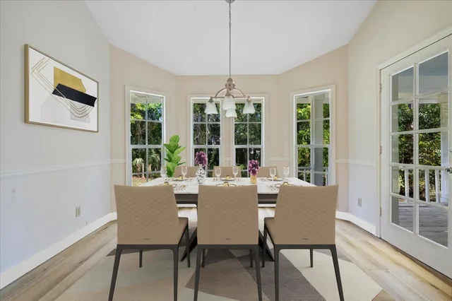 a dining room with furniture large windows and wooden floor