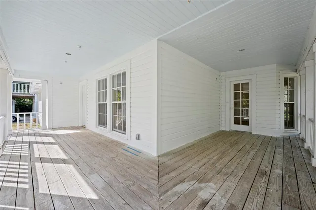 a view of a bedroom with wooden floor and windows