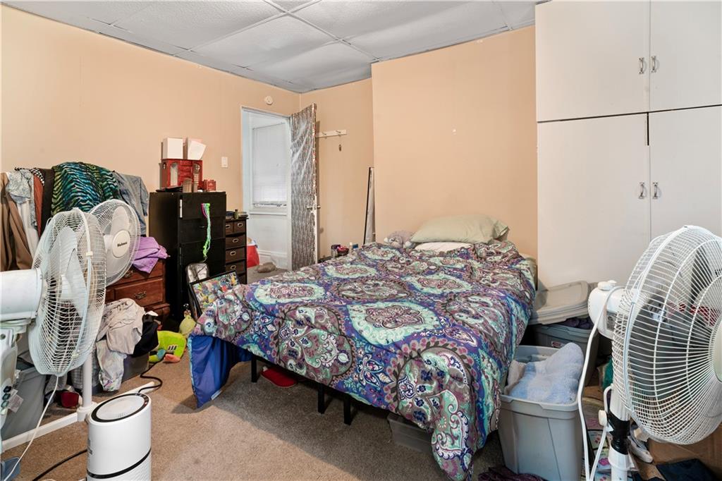 7709 Juniata Street Pittsburgh, PA 15218 - Photo 15 of 22 a bedroom with a bed and a chandelier